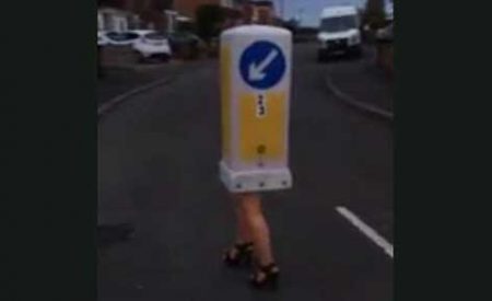 穿高跟鞋的女人头戴交通标柱试图穿过街道，然后…